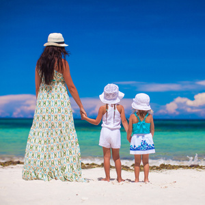 年轻的母亲带着她可爱的女儿在异国风情的沙滩上
