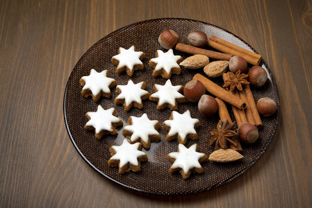 圣诞饼干和香料在一个木制的桌子上的盘子上