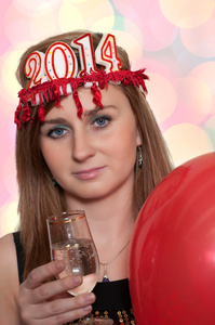 微笑的女士抱着新年的香槟，带颜色的散景的气球