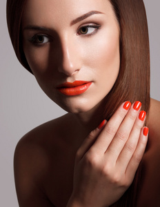 美丽的红指甲的女人。化妆和修指甲。红红的嘴唇