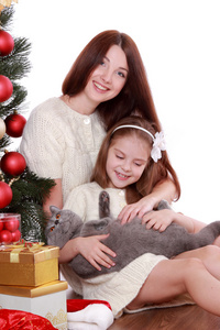 母亲和女儿在圣诞树上的猫