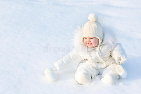 美丽的小女婴坐在白雪中