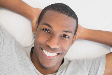 躺在床上休息的年轻黑人男人微笑着
