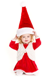 举着目前的戴着圣诞老人的帽子，孤立的白色衬底上的小孩