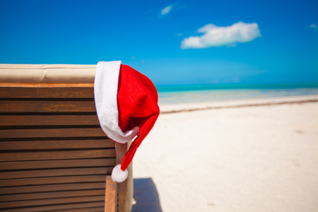 圣诞老人的帽子在椅子上贵妃在热带的加勒比海滩上