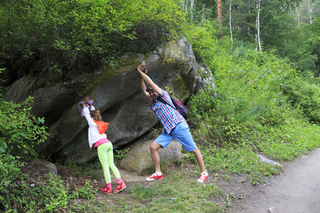 男人和小女孩拿着一块巨大的石头