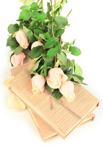 束美丽的玫瑰和白色衬底上分离出的书