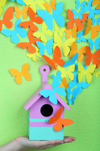 纸蝴蝶飞出巢框上绿墙背景图片