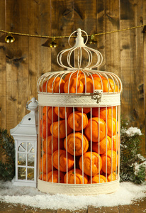在装饰的笼子里，木制的背景上的橘子