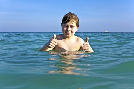 红头发的男孩享受在霏霏清晰温暖的水