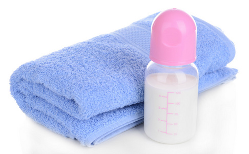 婴儿奶瓶奶与孤立在白色的毛巾