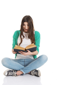年轻的女学生坐着读一本书