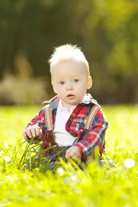 可爱的小宝宝在公园的草地上。甜甜宝贝在户外。面带笑容的情感孩子散步。一个孩子的微笑