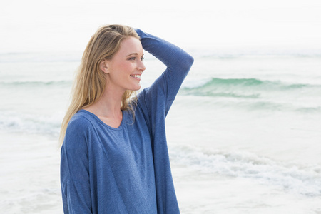 一个微笑的随便的女人在海滩的侧视图