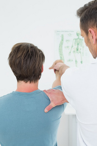 物理治疗师，一个男人的手臂伸展的后视图