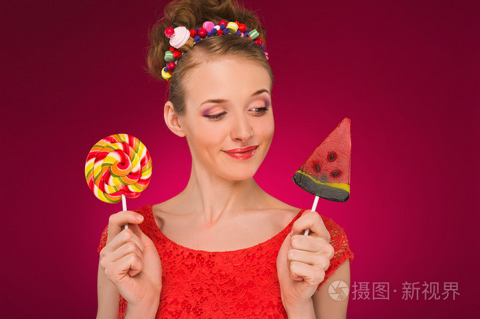 棒棒糖.女孩甜甜的糖在他们手中.红色背景