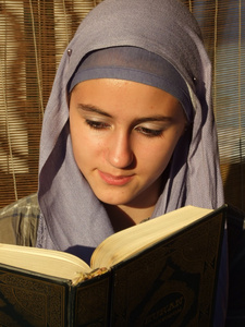 一个美丽的年轻穆斯林读到古兰经 