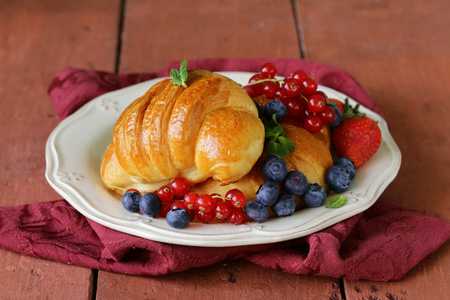 新鲜羊角面包早餐老式板上的浆果