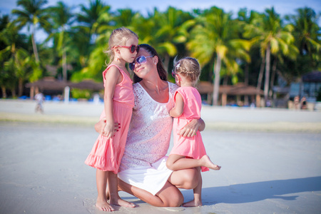 可爱的小女孩和年轻母亲，热带的白色沙滩上