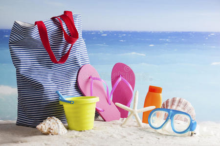 热带海滩上的沙滩包太阳眼镜和人字拖