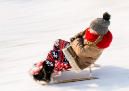 在冬天的时候滑雪橇的小女孩