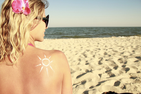 太阳霜在海滩上的女性背上的
