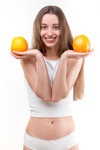女孩微笑着，白色背景上持有橘子
