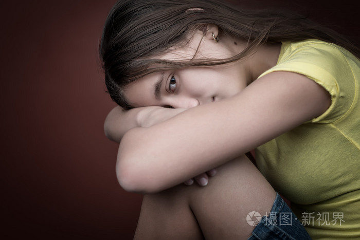 伤心的女孩,她的头搁在她的腿上