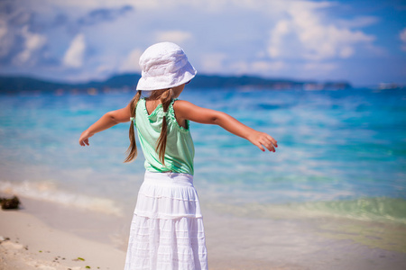 可爱快乐的小女孩，在现蕾的手散步的海滩度假