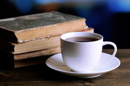 喝杯热茶与在明亮的背景上的桌子上的书