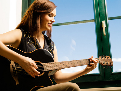 面带笑容的女人弹吉他的一个窗口