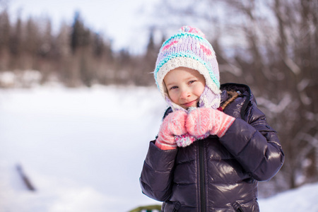 小可爱的快乐的女孩在雪地里阳光明媚的冬日的肖像