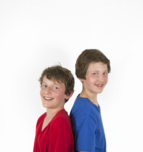 十几岁兄弟在红色和蓝色的衬衫，拥抱和构成