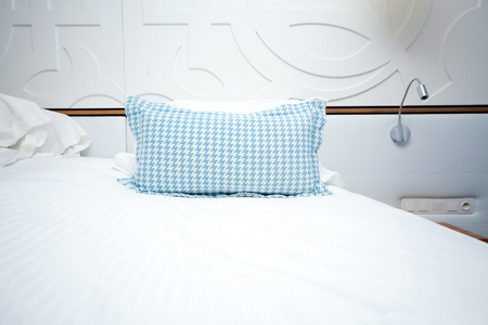 一张床，蓝色的枕头，在酒店房间里的形象