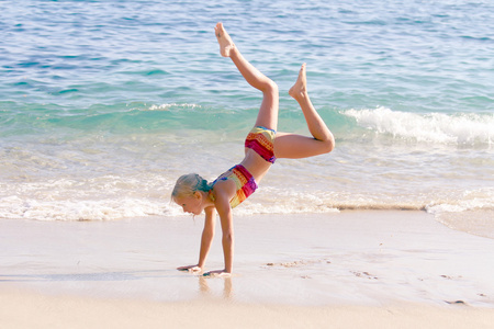 体操女孩在沙滩上