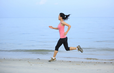 亚洲女人在海滩上运行