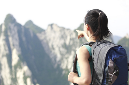 徒步旅行的女人站在蓝蓝的天空下