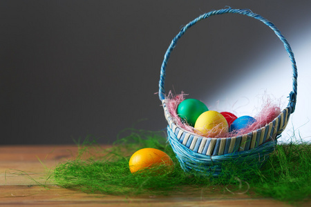 在木制的桌子上一篮子中的复活节彩蛋