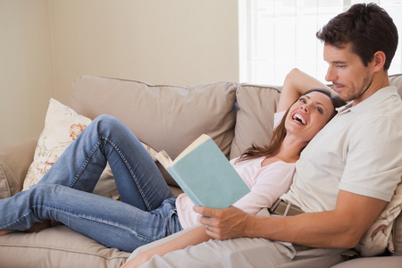 在沙发上放松对夫妇看书