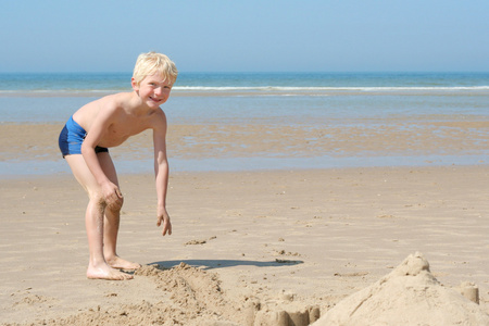 男孩在沙滩上玩沙