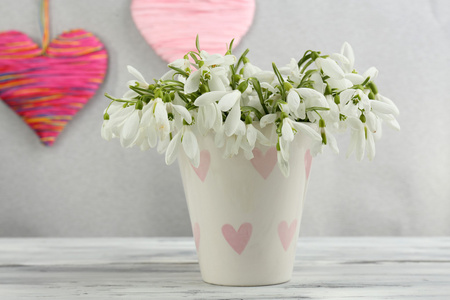 美丽的雪莲花，插在花瓶里用灰色的背景上的心