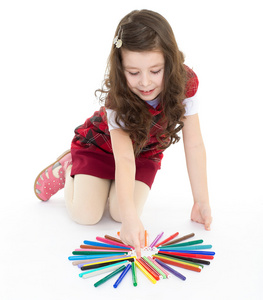 小女孩坐在地板上玩彩色笔
