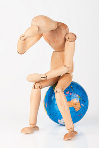 木坐在世界地球仪上的模特，以保护孤立无援