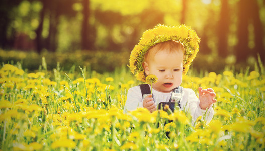 开心宝贝女孩在草地上与黄色的花朵 t 上一个花圈