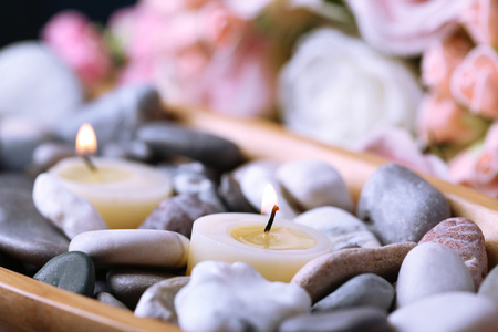 spa 石块与七支蜡烛的木桌前，在鲜花背景上的木碗