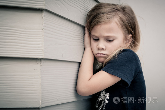 悲伤的小女孩,在一天的时间坐在靠近墙的肖像