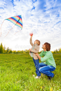 爸爸抱着孩子看放风筝
