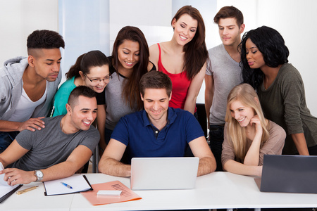 estudantes universitrios usando laptop juntos