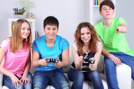 群年轻朋友玩视频游戏在家里