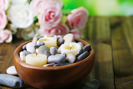 组成的 spa 石头 蜡烛和鲜花在明亮的背景上